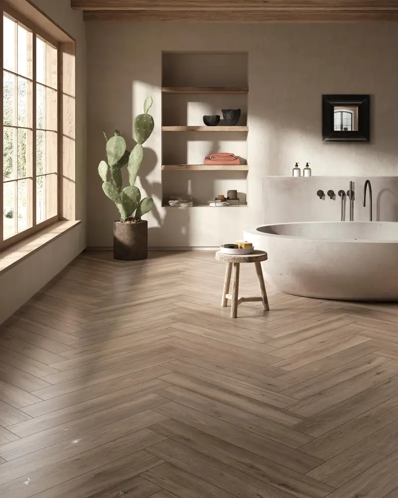 Salle de bain avec baignoire îlot et carrelage effet bois posé en bâtons rompus